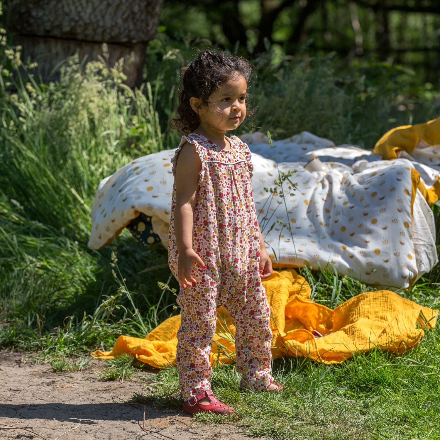 Little Green Radicals svītrainais kombinezons ar saullēkta rakstu